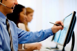person wearing suit & tie writing on computer screen