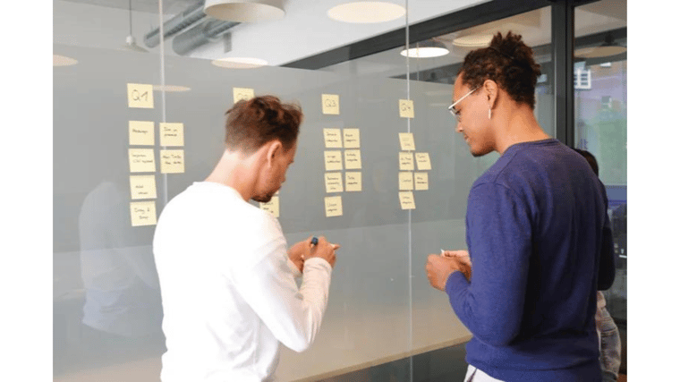 Two guys planning at a board sticky notes