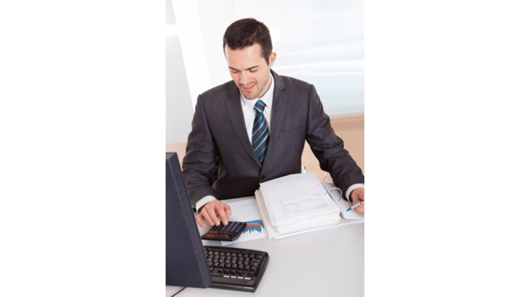 businessman using calculator and looking at book