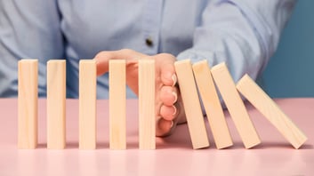 person holding back tumbling blocks