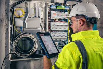 man uses tablet AI for predictive maintenance on machine